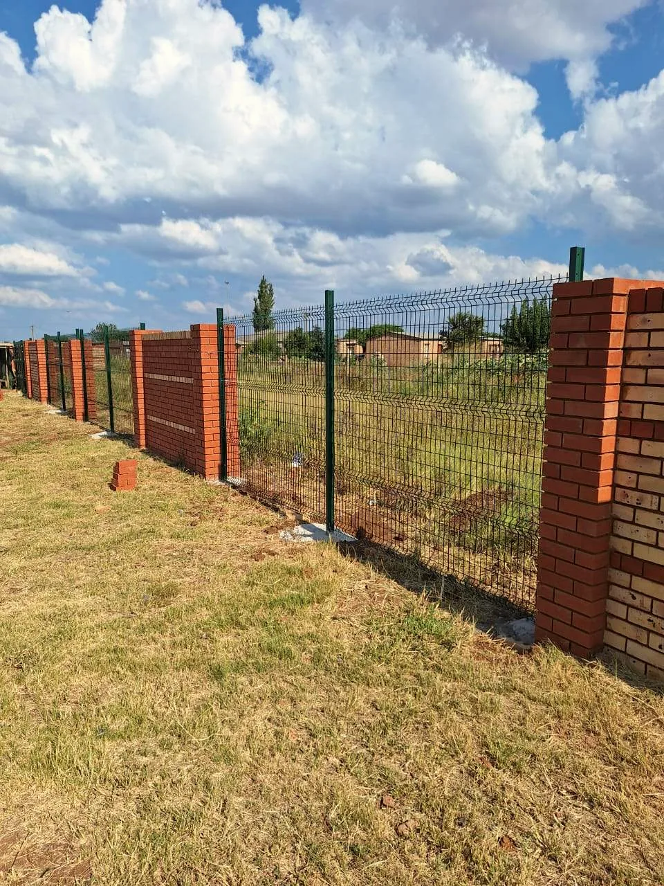 Brick pillars with mesh security fencing